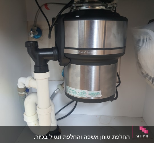 מטחנת אשפה מתחת לכיור עם צינורות פלסטיק